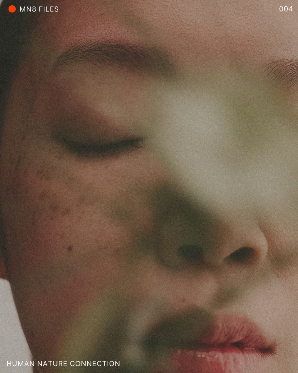 A close-up artistic photograph of a person's face with closed eyes, overlaid with soft green leaf shapes. 