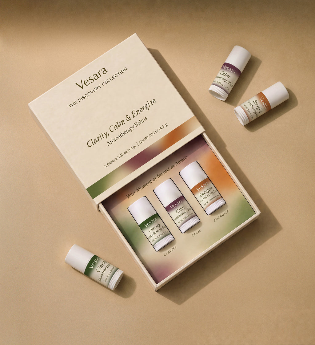 Vesara Discovery Collection open gift box with Clarity, Calm, and Energize aromatherapy balms on warm beige background